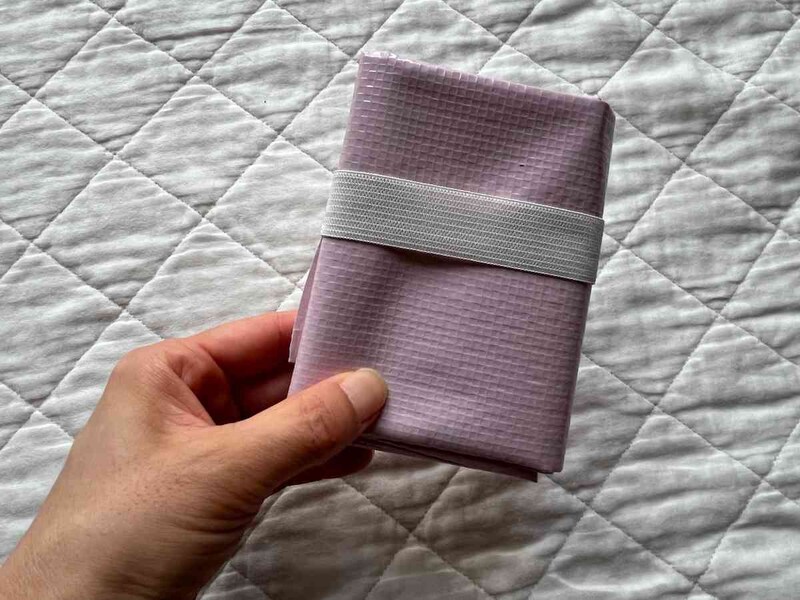 キャンドゥの「コンパクトレジャーシート」はたたんでゴムでとめられる