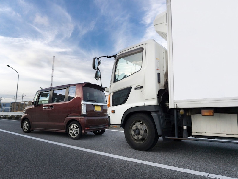 煽り運転。軽自動車とトラック　※画像：PIXTA
