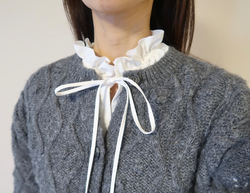 首もとのボタンを開けたカーディガンと合わせてもよし