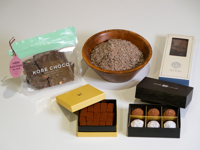 前列左：「メゾン ショーダン」パヴェド ポシビリテ（2160円）前列右：「トシ・ヨロイヅカ」トリュフ アノザ ヴァニーユ＆ジャンドゥーヤ（2800円）、後列左：「KOBE CHOCO」アーモンド＆ブラッククッキー アノザM（1188円）、後列右：「モンサンクレール」タブレットミルクティー（2401円）、※全て高島屋限定　中央は新素材「アノザ(R)M」