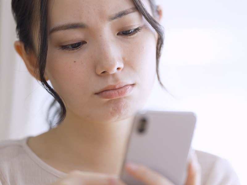 スマホでニュースを見る女性