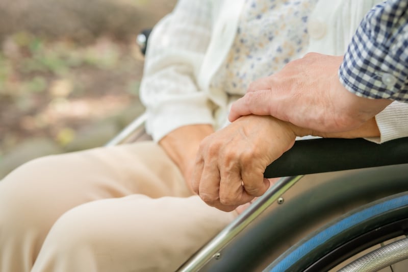 車いすの女性に手を添える男性