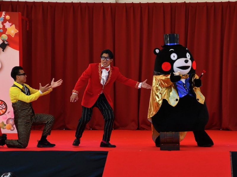 ヒョイッと鳩を出してみせるくまモン＝3月14・15日、熊本市