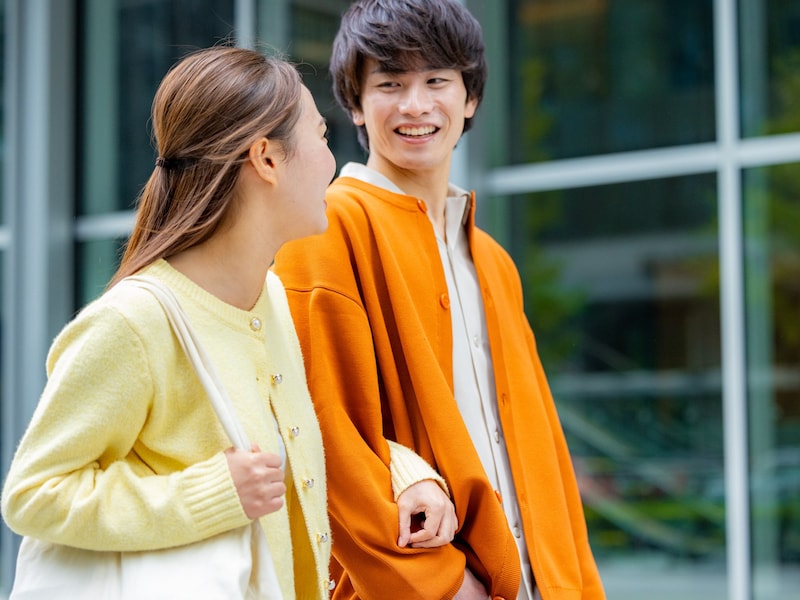 腕を組んで歩く若い夫婦