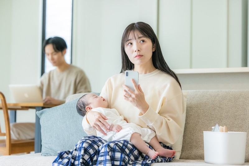 ソファで赤ちゃんを抱く女性