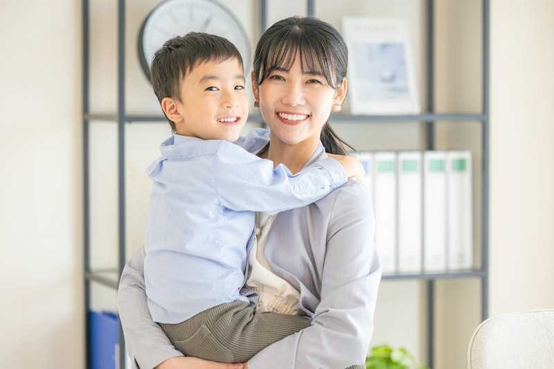 子どもを抱っこした働く女性