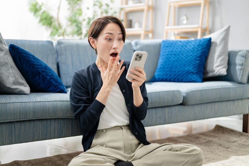 スマホを見て驚く女性