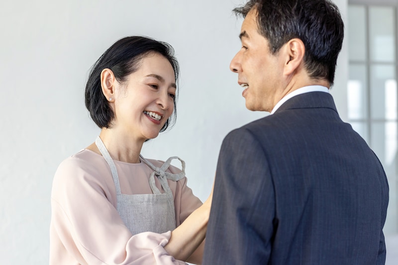 夫のネクタイを直す女性