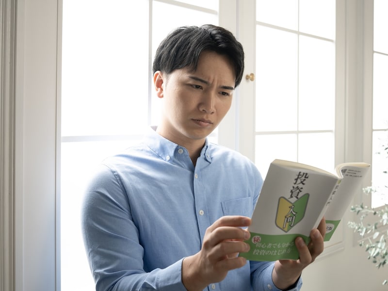 投資の本を読む男性