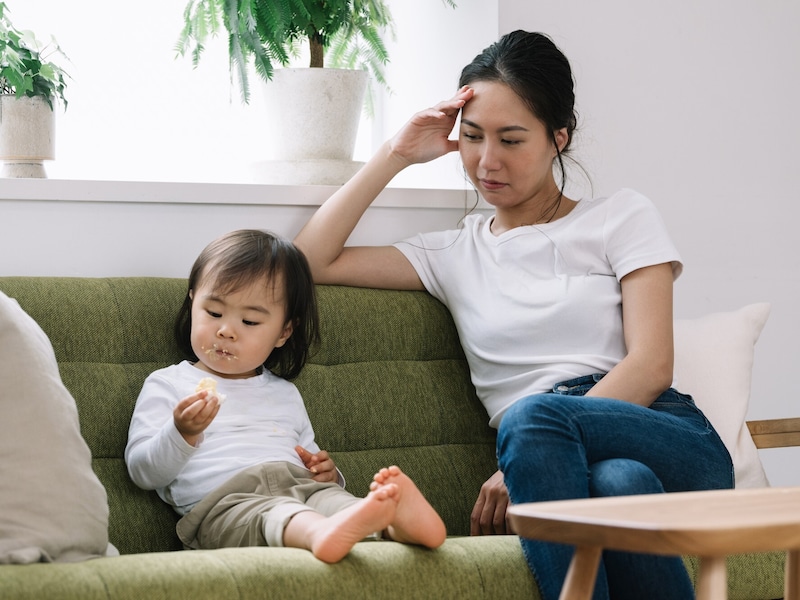 我が子を見つめる疲れた女性