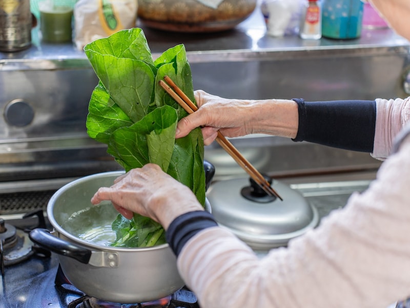 野菜をゆでるシニア女性
