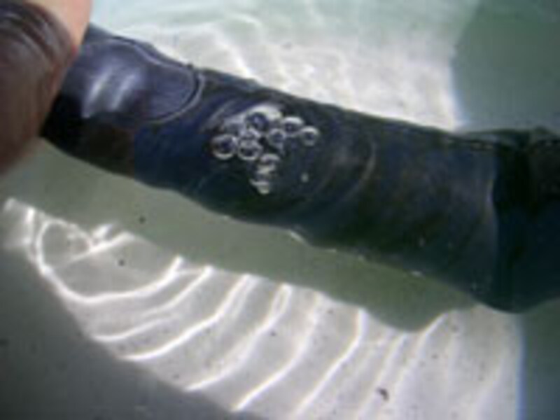 自転車のパンク修理：洗面器に張った水にチューブをつけると、穴が開いたところから泡が出る