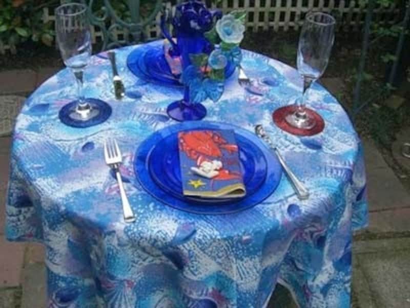 海を思わせるブルーの地に貝の文様があしらわれた夏らしいクロスを使ったコーディネート。ブルーのお皿が涼しさを演出します。