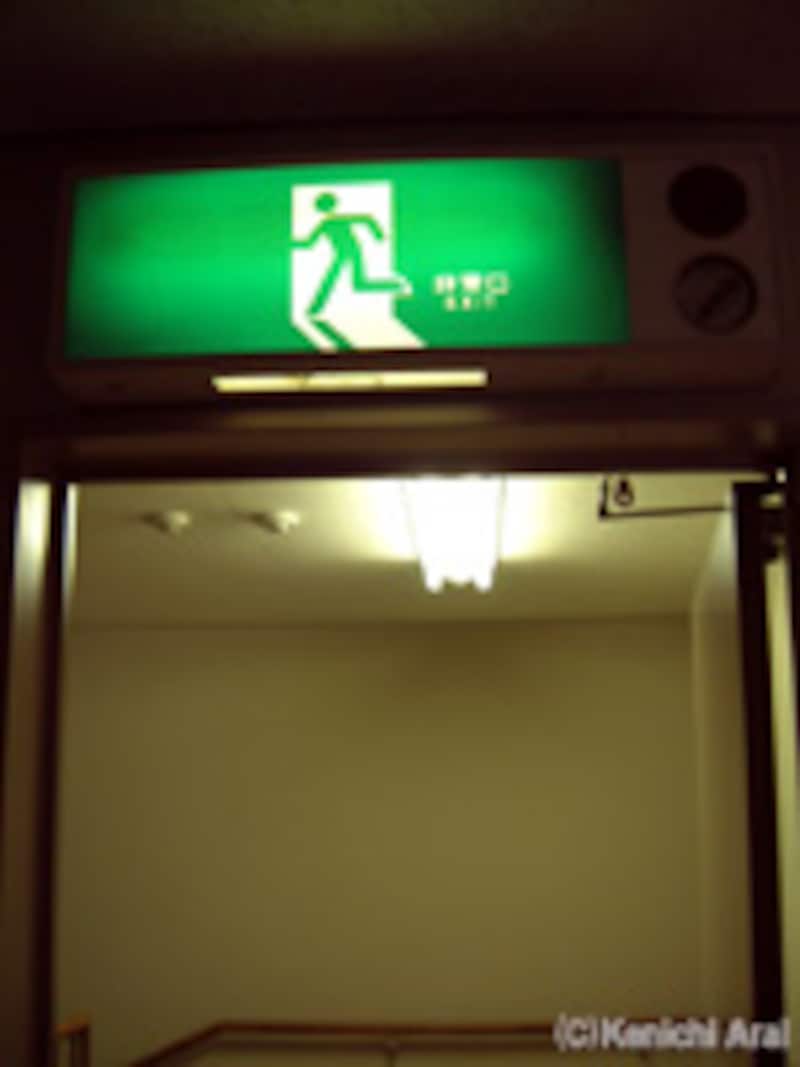 防火扉の上の避難口誘導灯