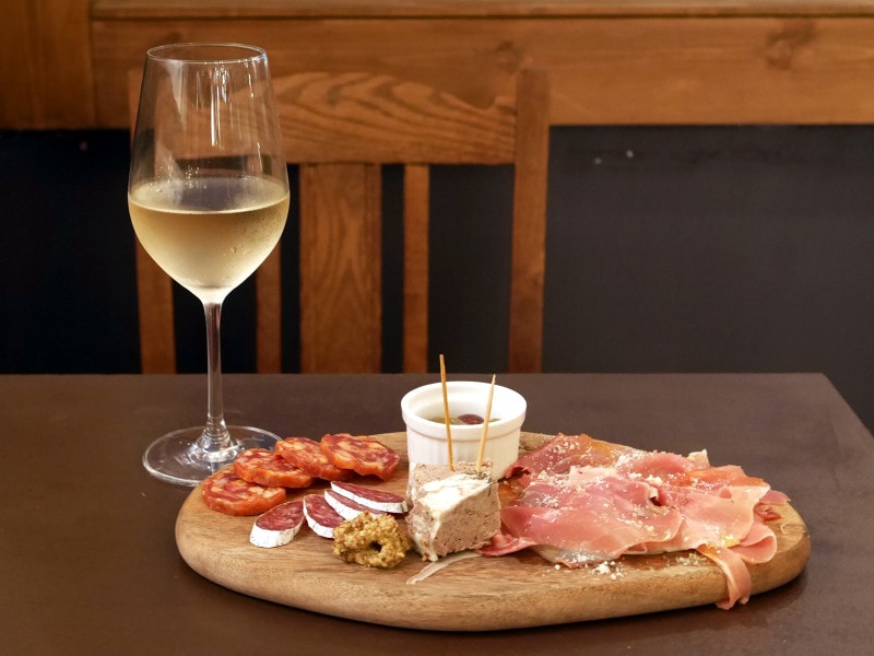 前菜の「こぼれシャルキュトリー（1200円）」をつまみながら、看板からメニューを検討（2018年9月16日撮影）