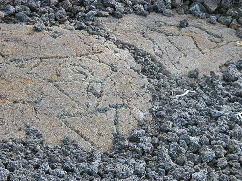 頭上に槍を掲げ、ヘルメットをかぶった戦士を描いたペトログリフ