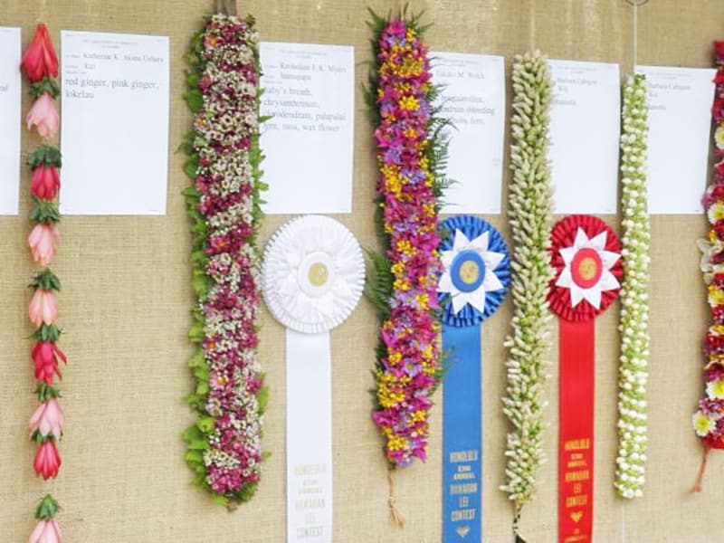 いくつもの花や葉、木の実を糸で通し、結び、編み込んで作られる花束のようなレイ