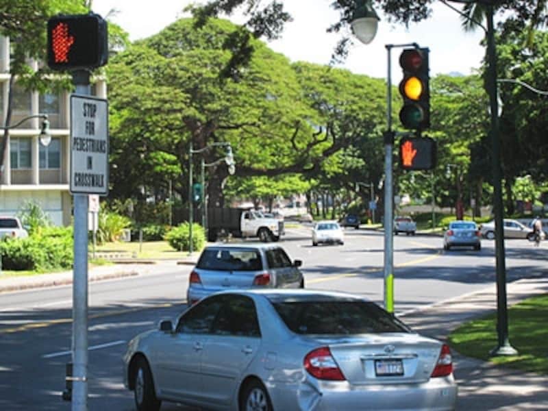 「STOP FOR PEDESTRIANS IN CROSSWALK」＝横断歩道に歩行者がいたら停止、の標識が立つ信号。ハワイには横断歩道法という法律がある
