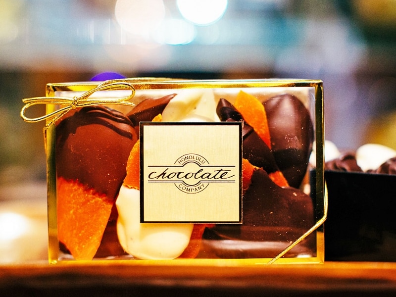工房で手作りされるチョコレートは無添加でフレッシュ！ パッケージも美しい。画像はチョコディップマンゴー（14ドル）