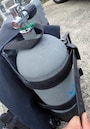 BCDのベルトでタンクをしっかりと留めます。緩いと水中でタンクが外れてしまうことも。BCDの種類によって留め方が異なるので注意しましょう。