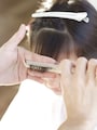 前髪にコームを入れながら手前に引き出す