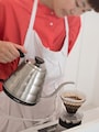 コーヒーを抽出する片山さん。この日は撮影用に赤を着てくれました。（白い空間に白服は難しい）