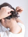 三つ編みの毛先をゴムで結んで固定する