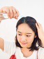 髪と頭皮に向かって水をスプレーする