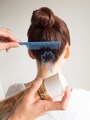 落ちてきた髪をコームとスプレーで仕上げる