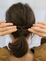 くるりんぱした毛束を二等分し左右に引っ張り、たるみをとる