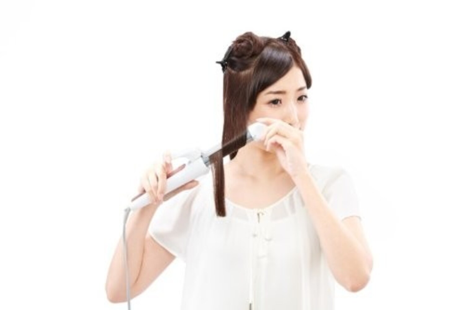 ヘアアイロンを使う女性