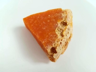 ミモレットの表面には、粉ダニによる穴やかじられたチーズの粉がついています。オレンジ色の部分を食べます