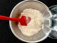 ボウルにグラニュー糖、ふるっておいた粉類を入れ、ゴムべらで混ぜます。水を加えたら、全体を大きくざっと混ぜます。このとき、混ぜ過ぎないように注意してください。