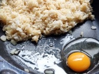 ごはんをよせて、卵を割り入れ、スクランブルエッグを作りながら、ごはんと炒め合わせ、えびを戻し入れ、小ねぎを加える。器に盛り、ライムを添える。