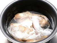 鶏肉2枚は、それぞれ別の袋に入れて漬け、多めの湯に沈め、保温時間を増やす。<br />
<br />
1時間～1時間30分後、鶏チャーシューをさわってみて、しっかりとしたコシが感じられるようであれば、火が通っている。柔らかければ、沸騰湯を足して追加保温する。