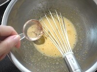 ときほぐした卵とグラニュー糖をボウルに入れ、全体が白っぽくもったりするまで泡立て器で混ぜたら、さらにサラダ油を加え、全体をよく混ぜます。