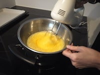 室温に戻しておいた卵にグラニュー糖を加え、混ぜ合わせます。ボウルの底に約60℃のお湯をあてて湯煎にし、ハンドミキサーの高速で泡立てます。