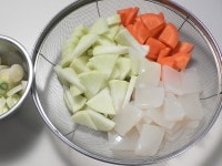 大根とにんじんはイチョウ切りにする。こんにゃくは野菜の大きさにあわせて切ってサッとゆがく。長ねぎは薄い小口切りにする。生姜は薄切りに、にんにくは2mmほどの厚さに切る。