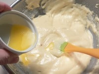 バターはヘラに落としながら、底をすくうように手早く混ぜ、粉チーズをさっくりと混ぜる。