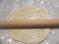 生地をラップではさんで麺棒で薄く伸ばす。