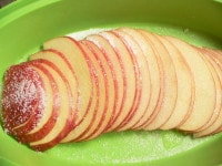 りんごは半分に切って芯をくり抜き、2mm厚に切り、斜めにずらして耐熱皿に並べ、グラニュー糖小さじ2とレモン汁小さじ1をふりかけ、600Wの電子レンジで3～4分加熱する。<br />
<br />
※残り半分のりんごは生のまま使います。