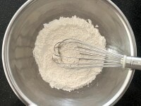 強力粉、砂糖、塩をボウルに入れ、泡立て器でよく混ぜます。これで粉類をふるいにかける必要がなくなります。