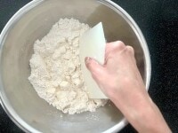 カードでバターを粉と合わせながら切り刻んで、全体がさらさらした粉状になるようにします。この作業はバターが手の温度で溶けてこないよう、手早く行うことが肝心です。