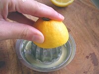 レモンを横半分に切り、飾り用の輪切りを２つ作ります。そしてレモン汁を100ｍｌ分絞ります。<br />
