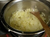 鍋にサラダ油とみじん切りのニンニクを入れて熱し、炒めます。香りが出てきたら粗みじん切りのタマネギを加え、しんなりするまで炒めます。<br />