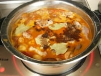 次に水、スープの素、ローリエ、パプリカを加え中火弱で20分ほど煮詰めます。<br />