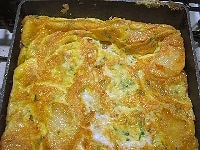 卵全体に火が通り固まったら、一度ひっくり返すようにして大きなフタや皿にオムレツを乗せ、そのまままたフライパンに戻して、もう片面も焼き、焼き色がついてしっかり火が通ったら完成です。