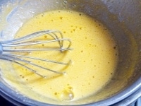卵黄とグラニュー糖をボウルに入れ、白っぽくなるまで泡立て器で混ぜ合わせる。<br />