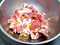 ボウルに豚肉とおろした柚子の皮、千切りの生姜、片栗粉、日本酒を加え、手でよく揉む。 <br />