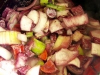 煮込み用に鍋にオリーブオイルと野菜を入れて弱めの中火にかけ、野菜を炒める。